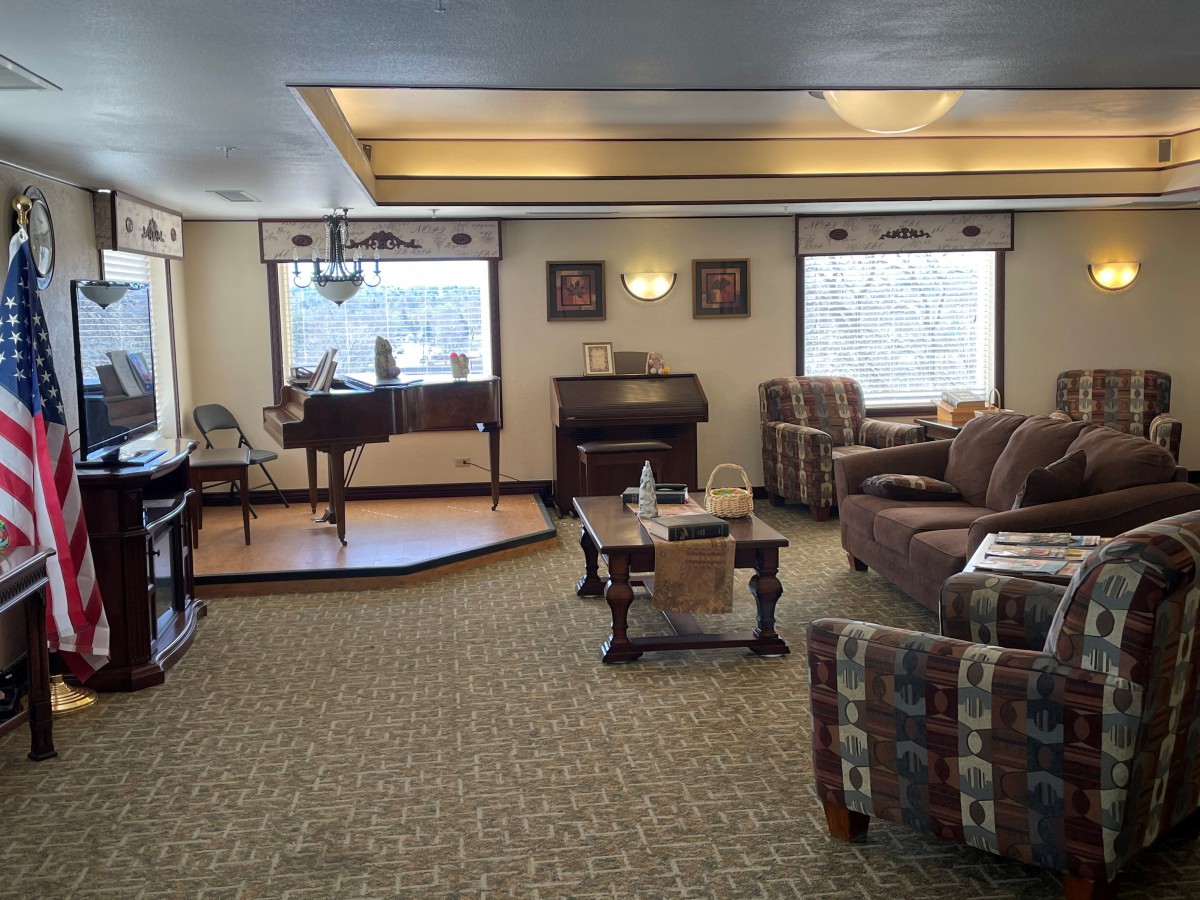A cozy living room with a piano and comfortable seating.
