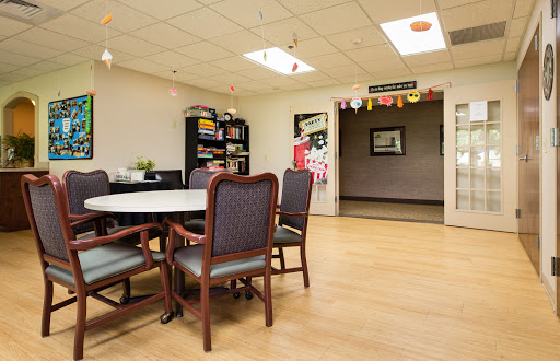 A cozy meeting room with a round table, comfortable chairs, and decorative elements.