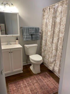 A clean and organized bathroom with a sink, toilet, towels, and shower curtain.