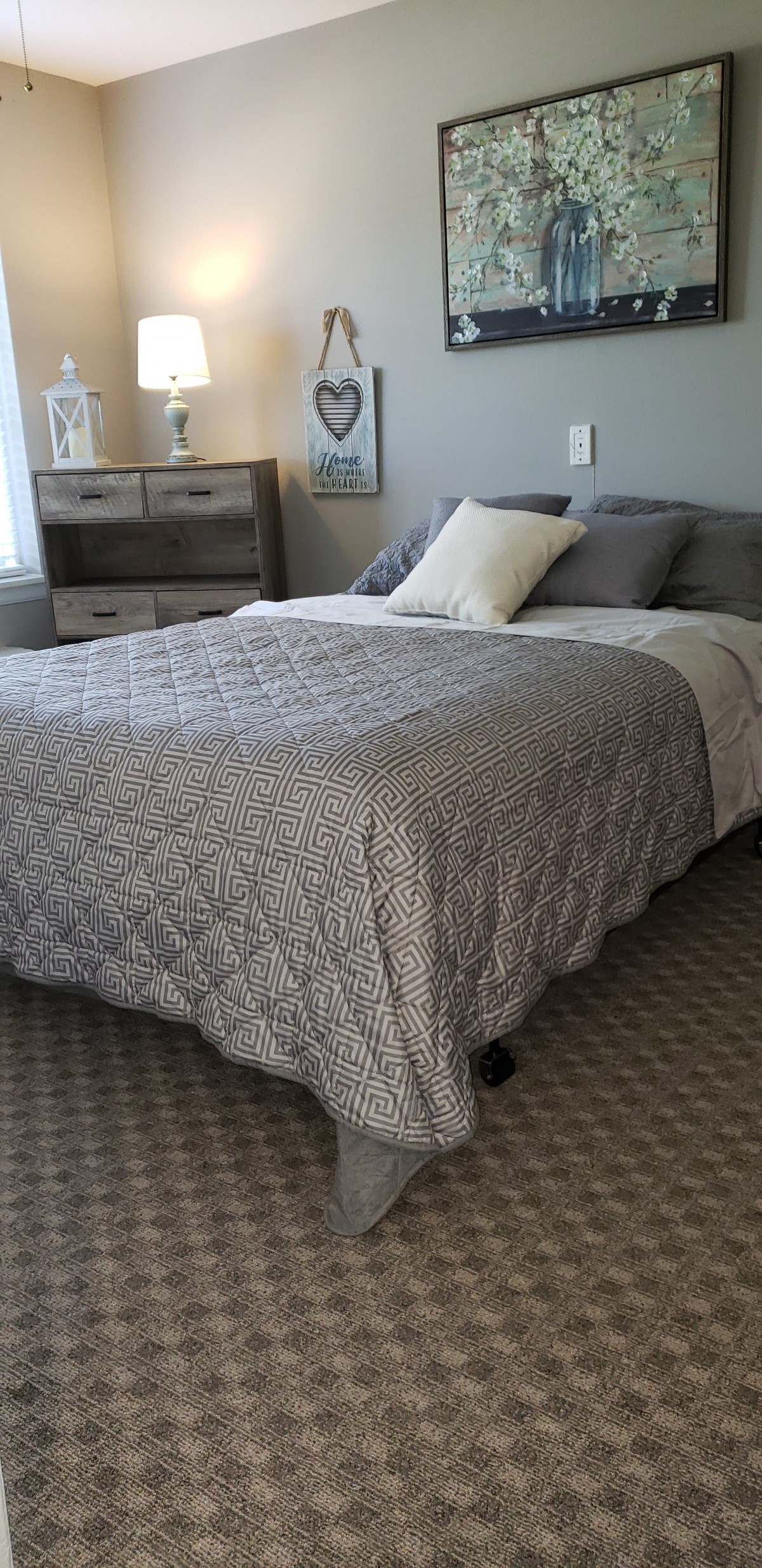 A cozy bedroom with a neatly made bed and decorative pillows.