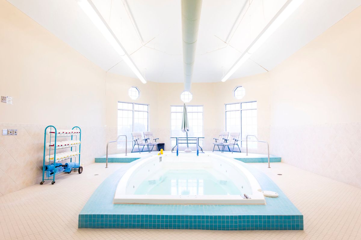 A bright and modern indoor spa area featuring a hot tub.