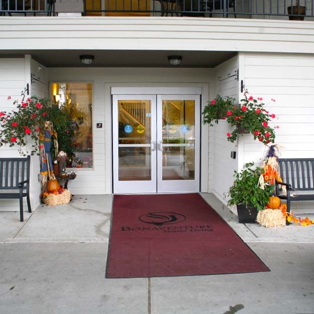 An entrance decorated with autumn-themed elements, including pumpkins and plants.