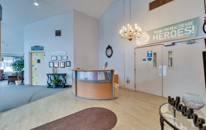 A welcoming reception area featuring a chandelier, a curved desk, and decorative elements.