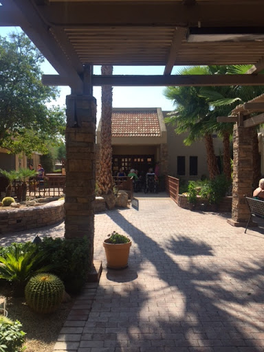 A serene courtyard with stone features and lush greenery, basking in the sunlight.