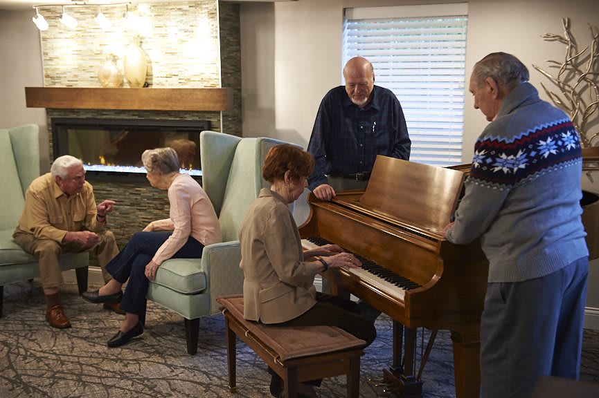 A group of seniors enjoying a social gathering with piano music.
