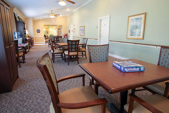 A spacious dining and recreational area with tables and chairs, featuring a board game ready for play.