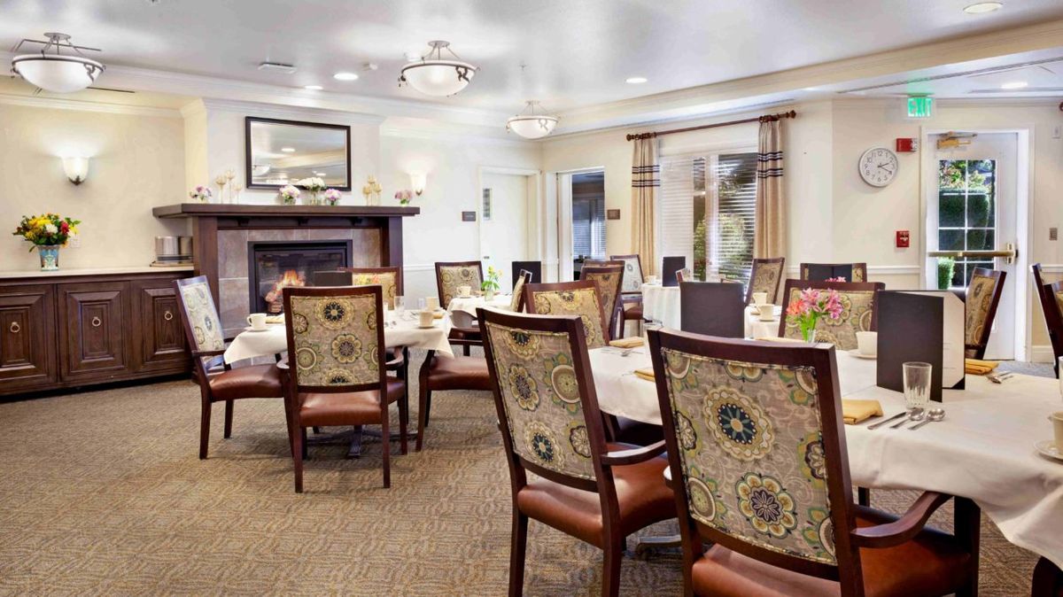 An elegantly designed dining area with upholstered chairs and well-set tables.