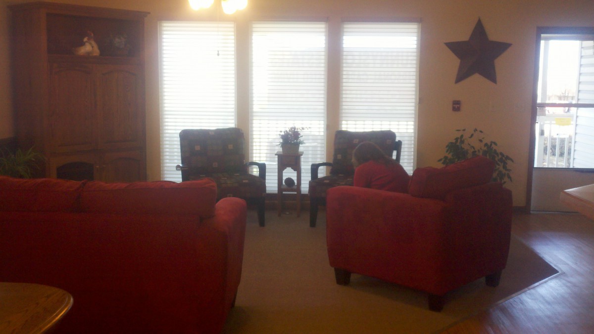 A cozy living room with a seating arrangement facing large windows.