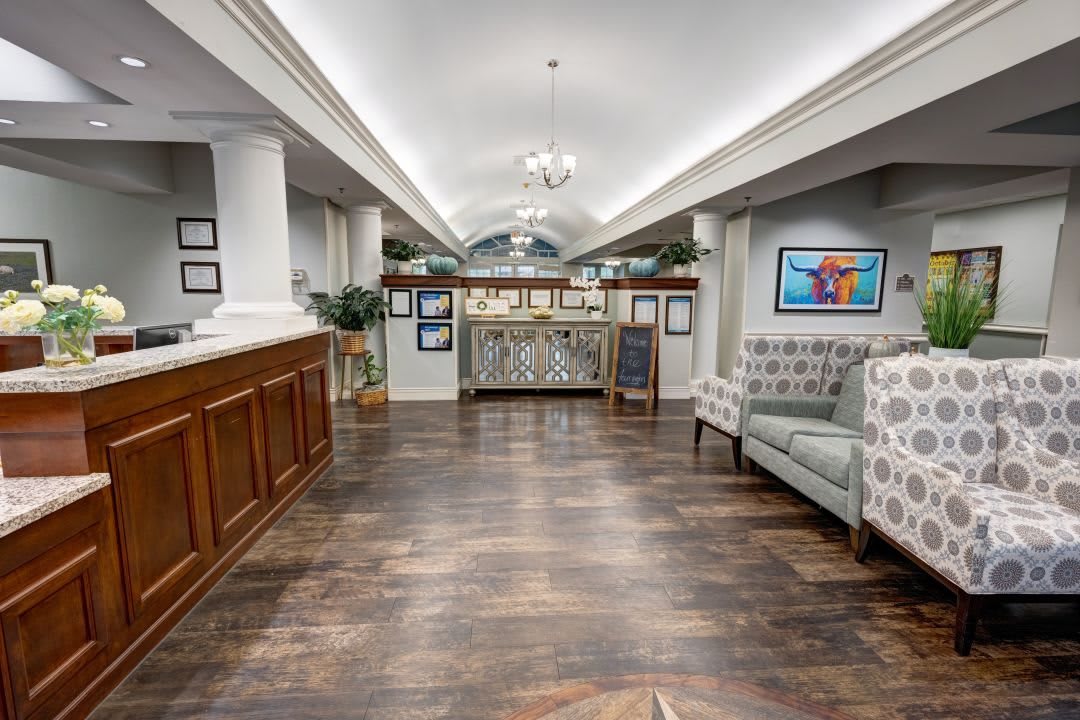 A modern lobby area featuring a wooden reception desk, comfortable seating, and stylish decor.