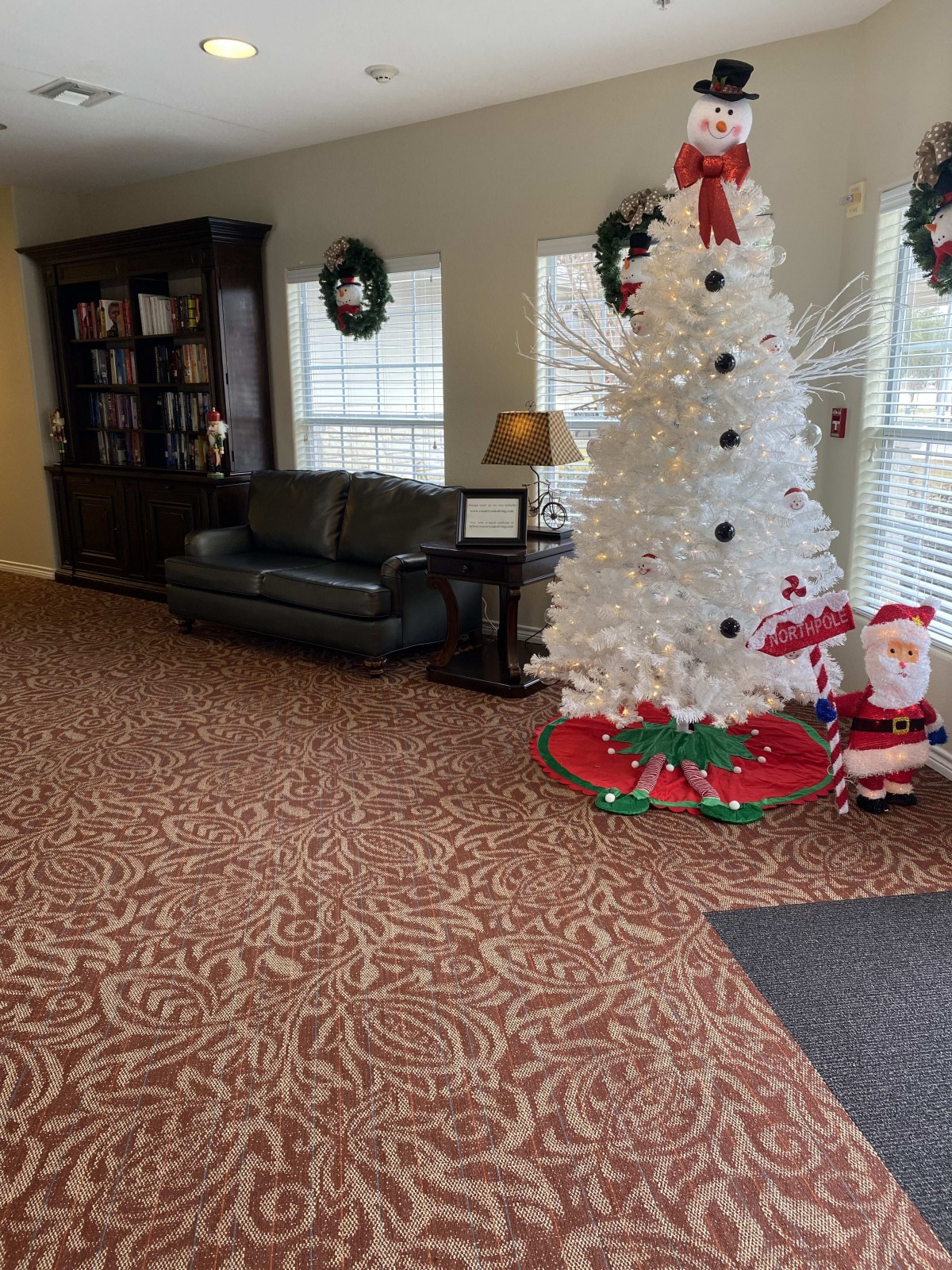 A cozy living room adorned with a white Christmas tree and festive decorations.