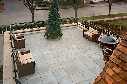 A spacious patio area featuring elegant outdoor furniture and a decorative tree.