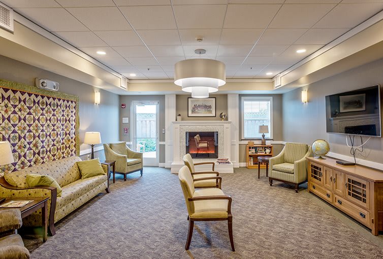 A cozy living room with comfortable seating, a central fireplace, and elegant lighting.