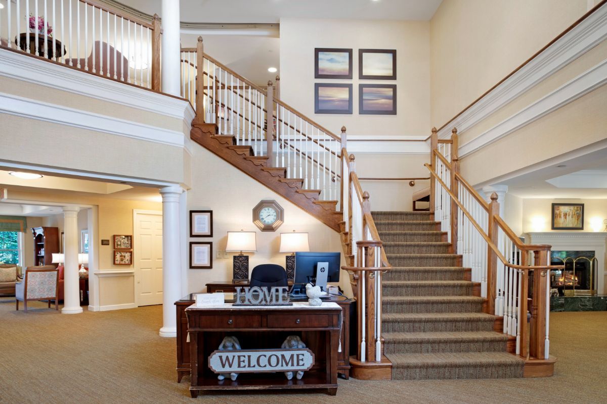 A cozy interior featuring a staircase and a reception desk with welcoming decor.