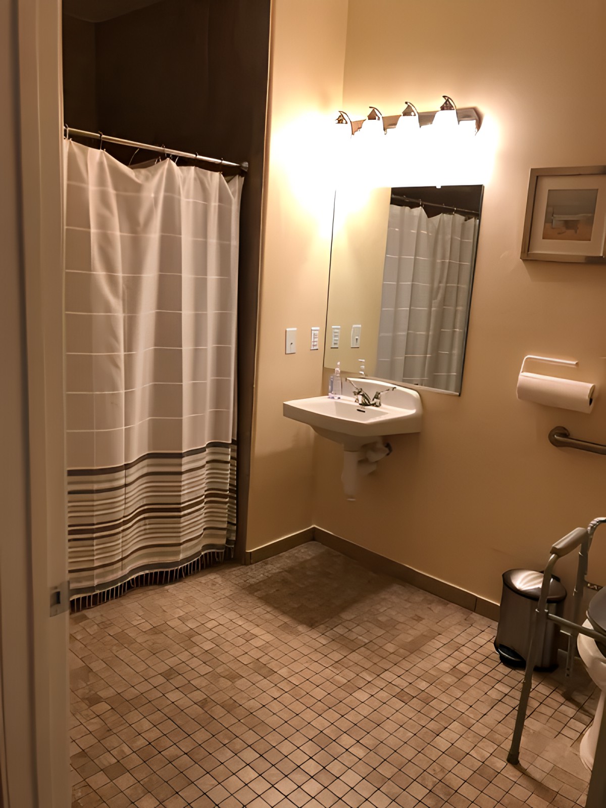 A cozy bathroom with a shower, sink, and mirror.