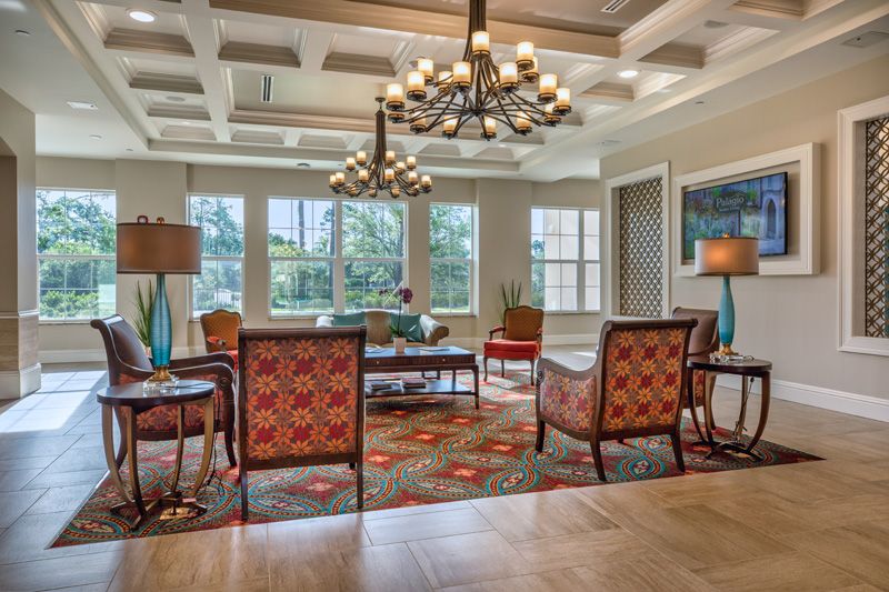 A spacious and elegant living room with comfortable seating and a large chandelier.