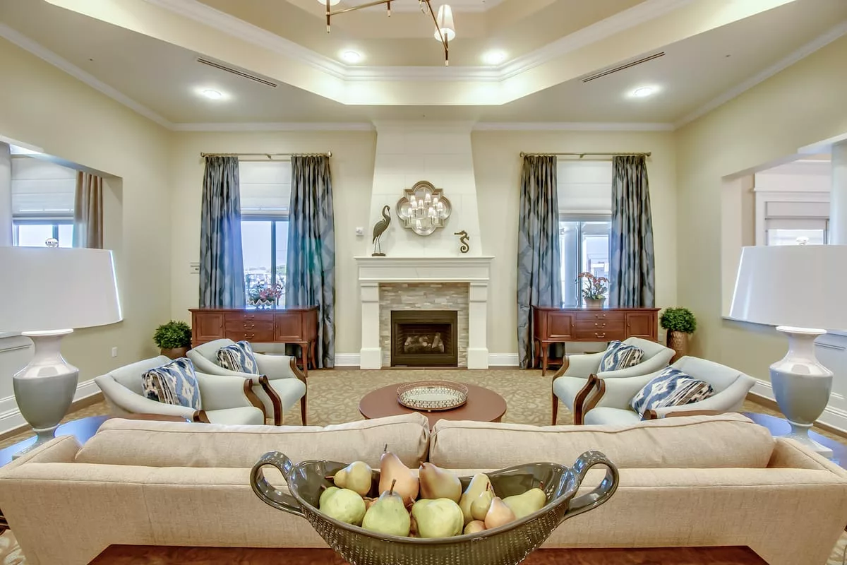 A spacious and elegantly designed living room featuring a central fireplace, comfortable sofas, and stylish decor.
