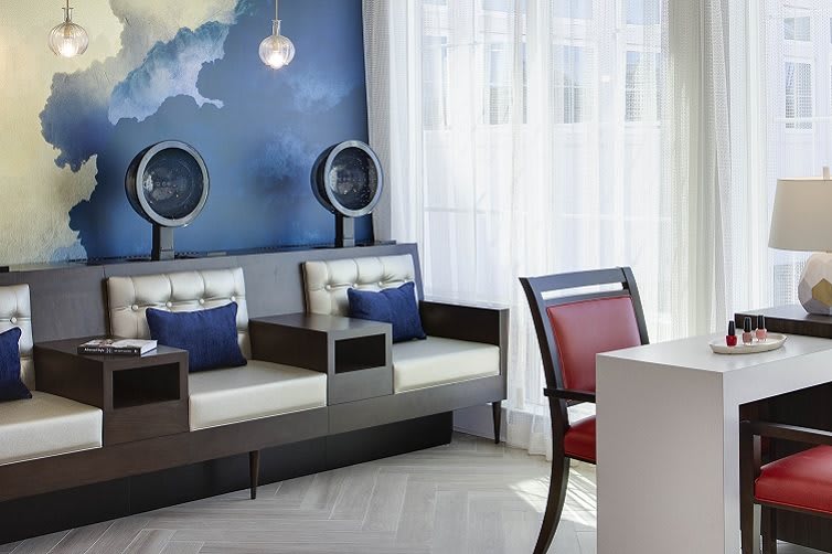 A modern salon interior featuring stylish seating and hairdryers.