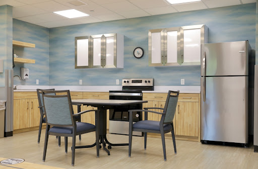 A modern kitchen and dining area featuring a table with chairs, an oven, and a refrigerator.