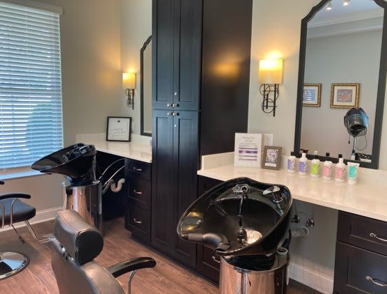 A stylish salon interior featuring hair wash stations and mirrors.