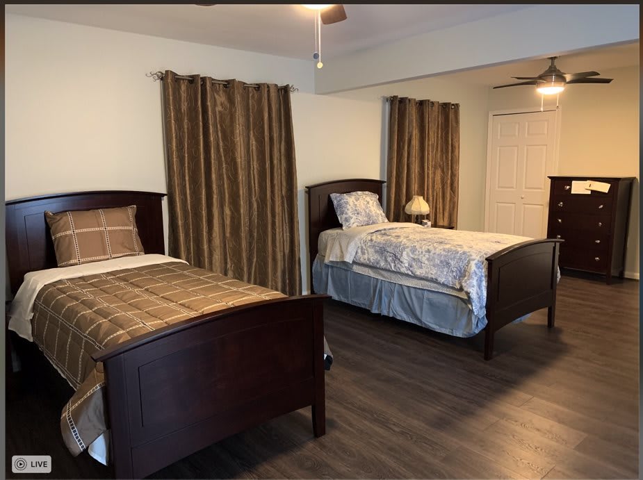 A cozy bedroom featuring two single beds with wooden frames and matching curtains.