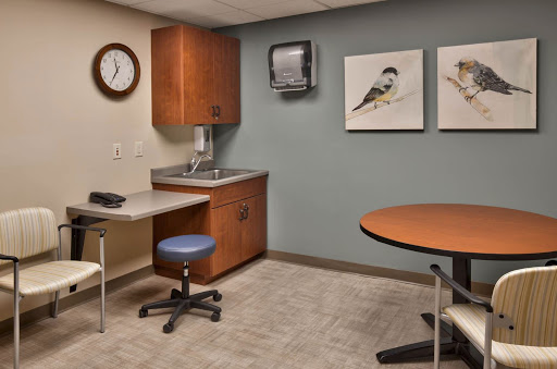 A calm and organized medical office waiting area, featuring modern furniture and bird artwork on the walls.
