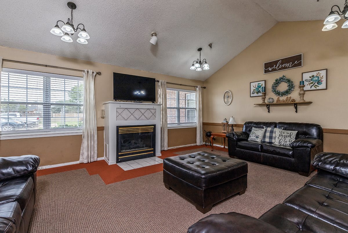 A cozy living room with a fireplace and television, featuring comfortable seating and elegant decor.