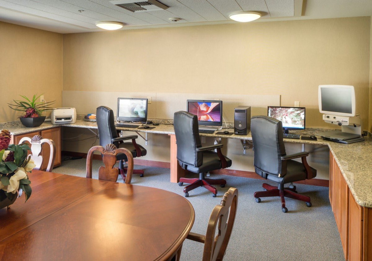 A well-equipped office space featuring workstations with computers and a meeting table.