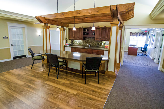 A modern kitchen and dining area with wooden furniture and pendant lighting.
