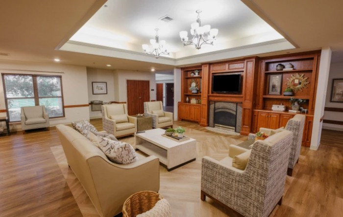 A cozy living room with comfortable seating, a fireplace, and a television.