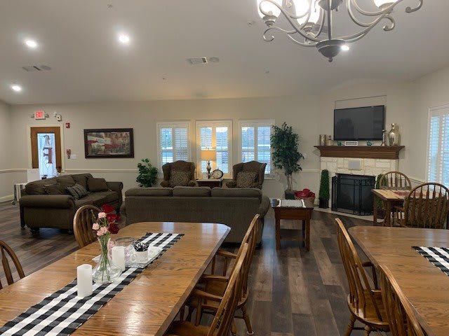 Spacious open-plan living and dining area with cozy seating, a fireplace, and elegant decor.