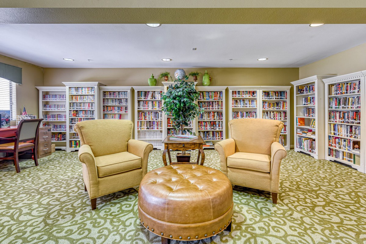 A cozy library corner with armchairs and bookshelves.