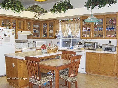 A cozy kitchen with wooden cabinets, an island counter, and various appliances.