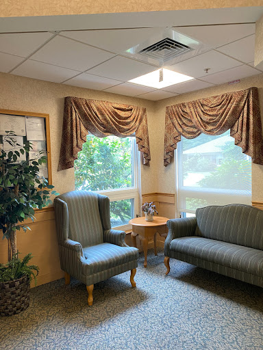 A cozy waiting area featuring comfortable seating, soft curtains, and natural light streaming in from the windows.
