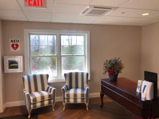 A cozy interior space featuring two striped chairs near a window and a wooden table with a plant.