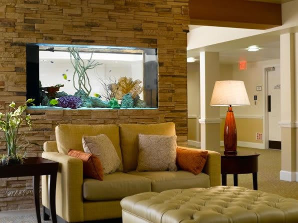 A cozy living room with a sofa, aquarium, and warm lighting.