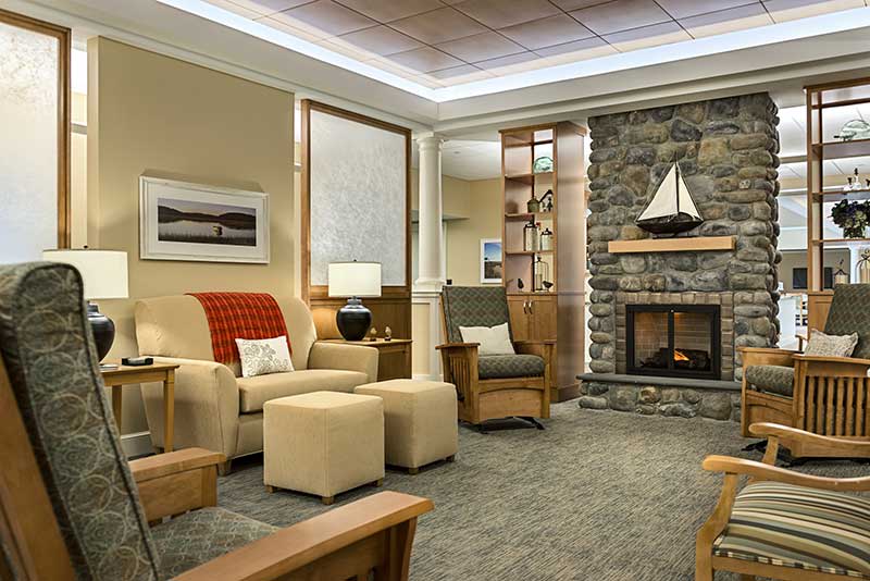 A cozy and modern living room with comfortable seating and a stone fireplace.