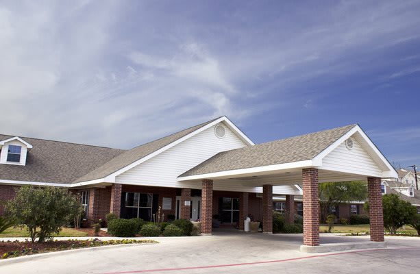 A commercial building with a covered entrance and clear blue skies.