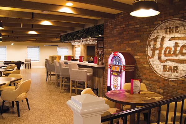 A cozy bar interior featuring a jukebox and comfortable seating.