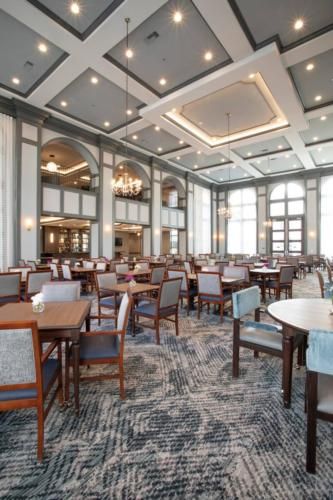 A spacious dining area with elegant decor, featuring large windows and modern furnishings.