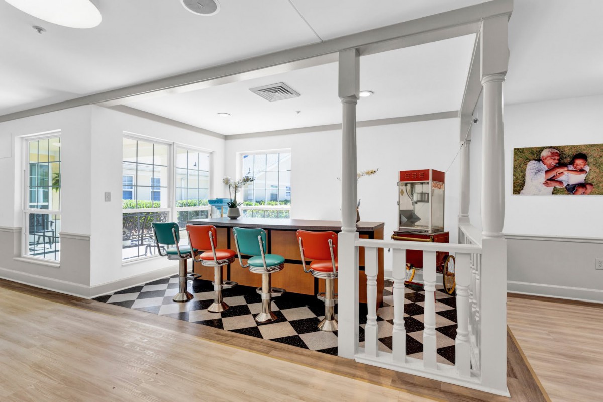 A retro-style diner interior with colorful bar stools and a checkered floor.