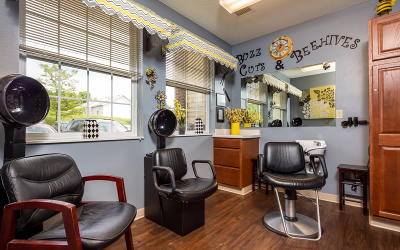 A cozy hair salon interior featuring styling chairs and a hooded hair dryer.