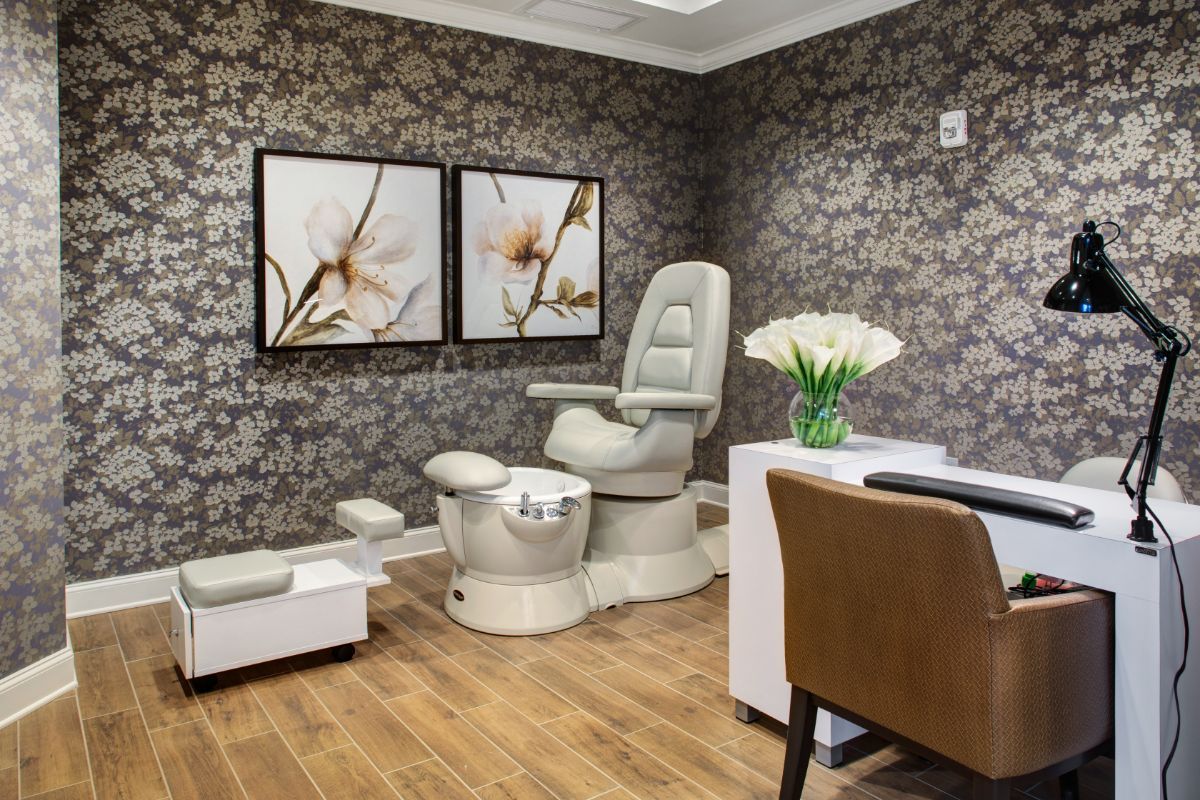 A luxurious spa setting featuring a pedicure chair and elegant floral decor.