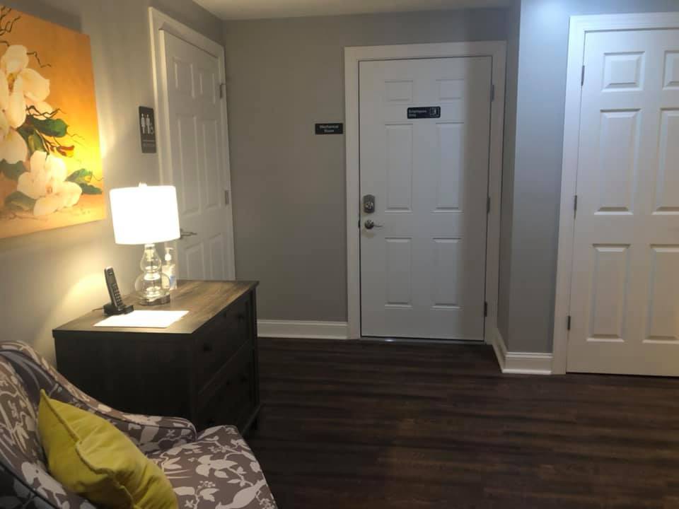 A cozy living room with a side table and lamp near the entrance.