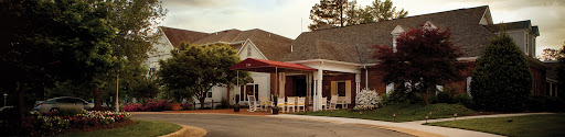 A charming residential building featuring a welcoming porch with rocking chairs.