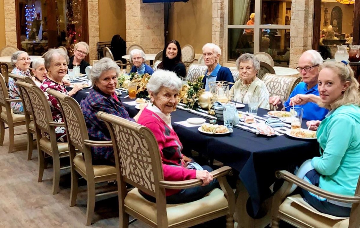 A group of elderly individuals enjoying a meal together indoors.