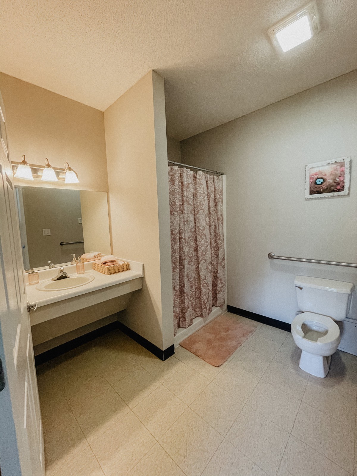 A clean and organized bathroom with a shower, sink, and toilet.