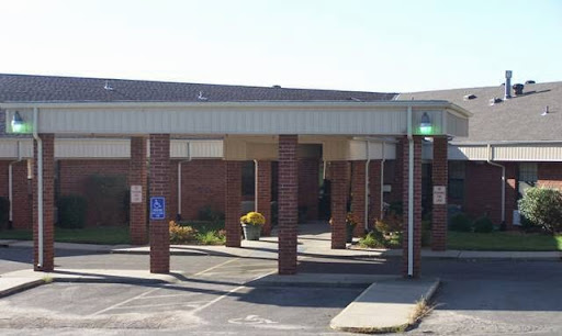 A healthcare facility with a welcoming entrance and parking area.