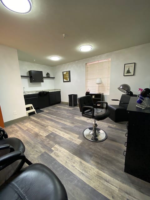 A modern hair salon interior with styling chairs and workstations.