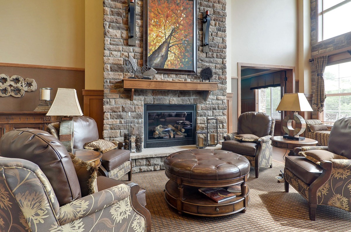 A cozy living room with a stone fireplace and comfortable seating.