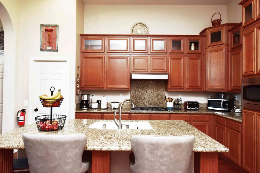 A modern kitchen with wooden cabinets and a granite countertop island.